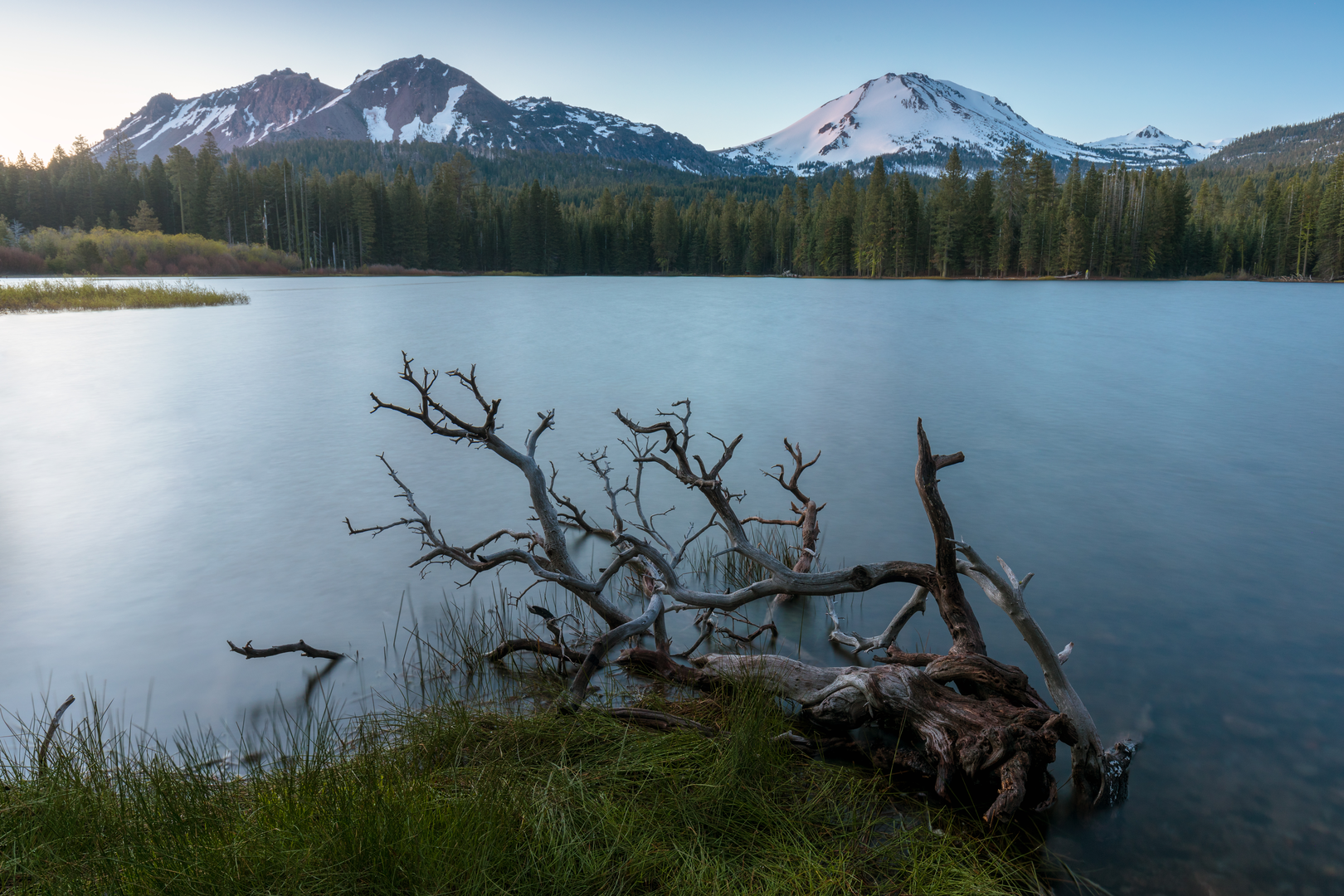 An image depicting the trail Manzanita Creek Trail from Manzanita Lake and its surrounding area.
