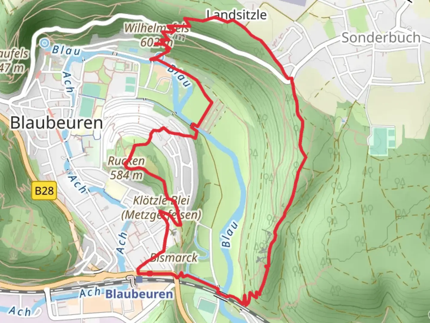 An image depicting the trail Blau and Wilhelmsfels via Blaubeurer Felsenstieg and its surrounding area.
