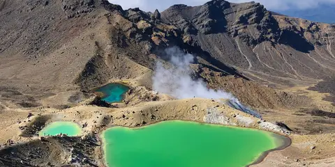 An image depicting the trail Tongariro Alpine Crossing with Mount Tongariro and Mount Ngauruhoe and its surrounding area.