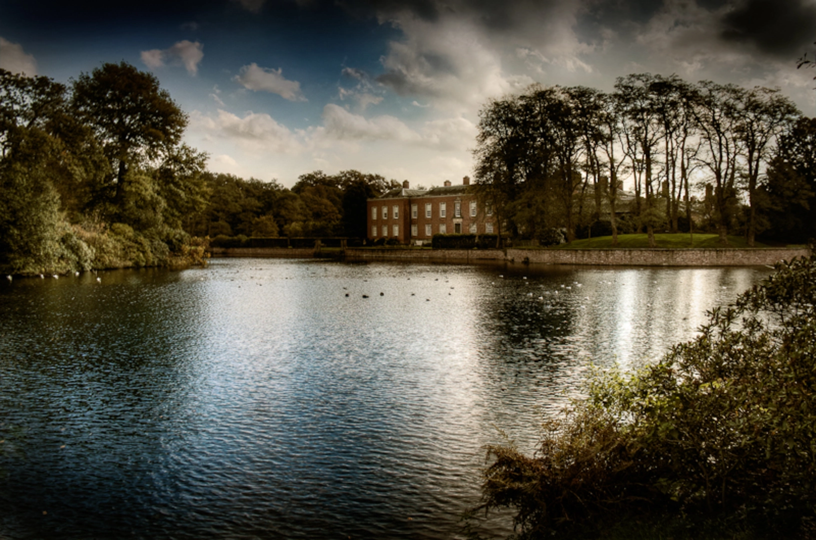 An image depicting the trail Cheshire Ring Canal Walk in Dunham Massey Country Park and its surrounding area.