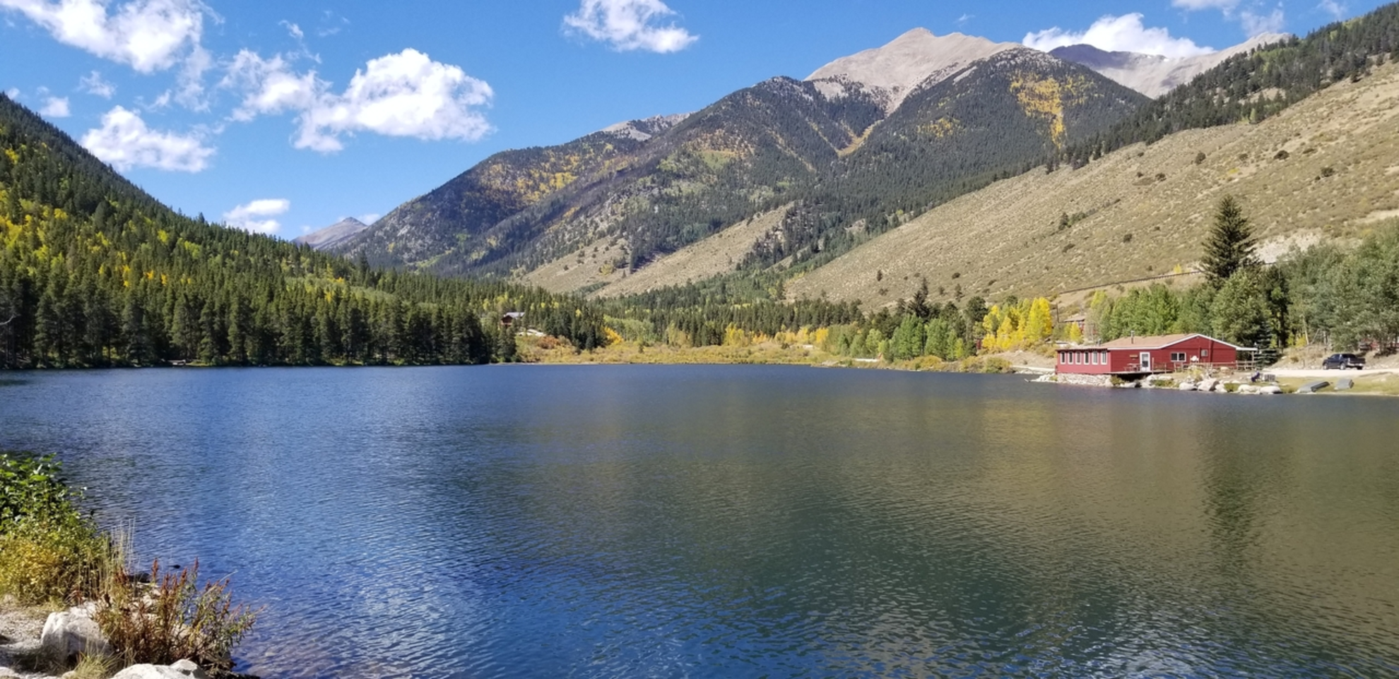 An image depicting the trail Rainbow Lake via Peaks Trail and its surrounding area.
