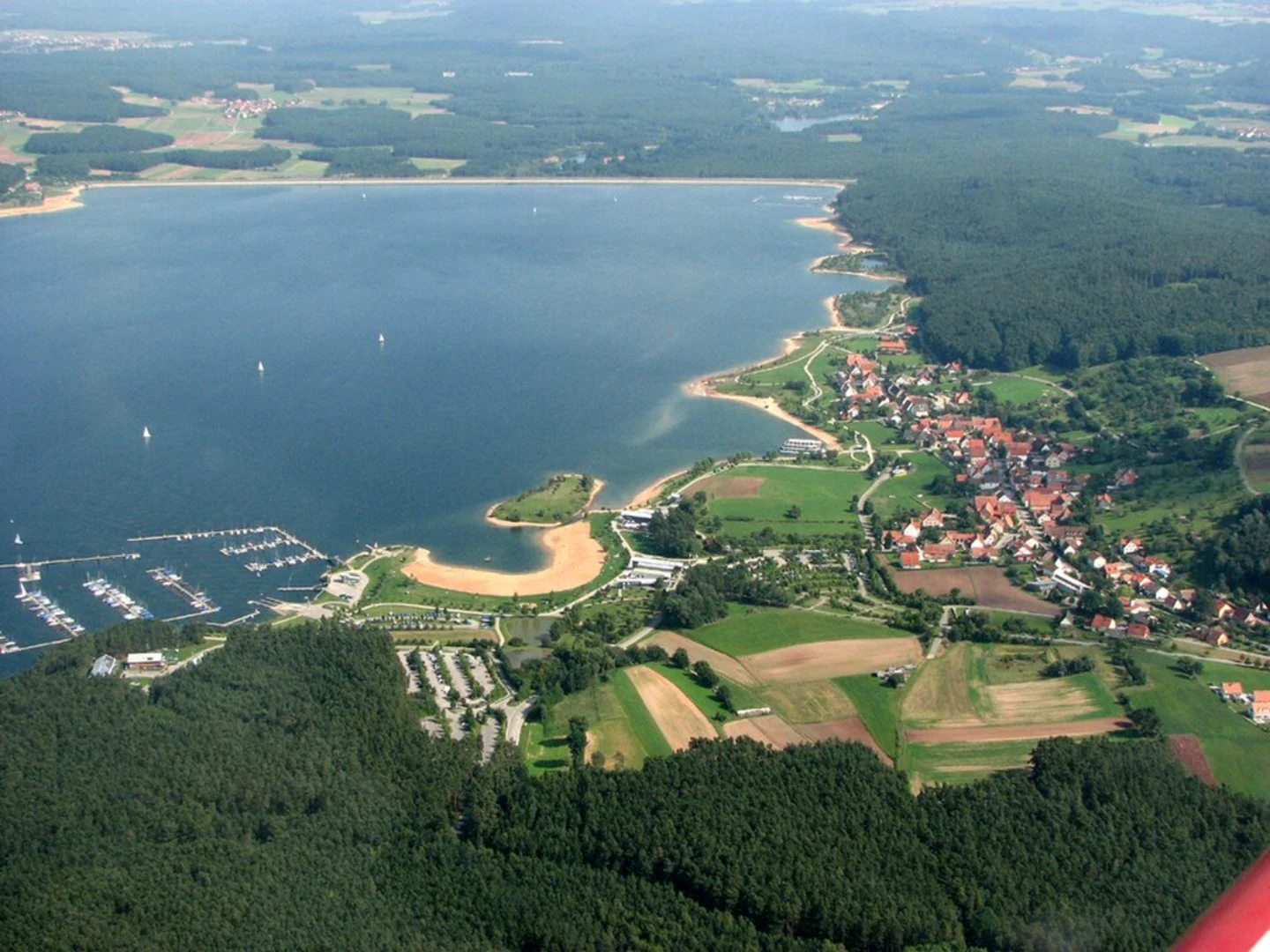 An image depicting the trail Fraenkisches Seenland Loop along Kleiner Brombachsee and its surrounding area.
