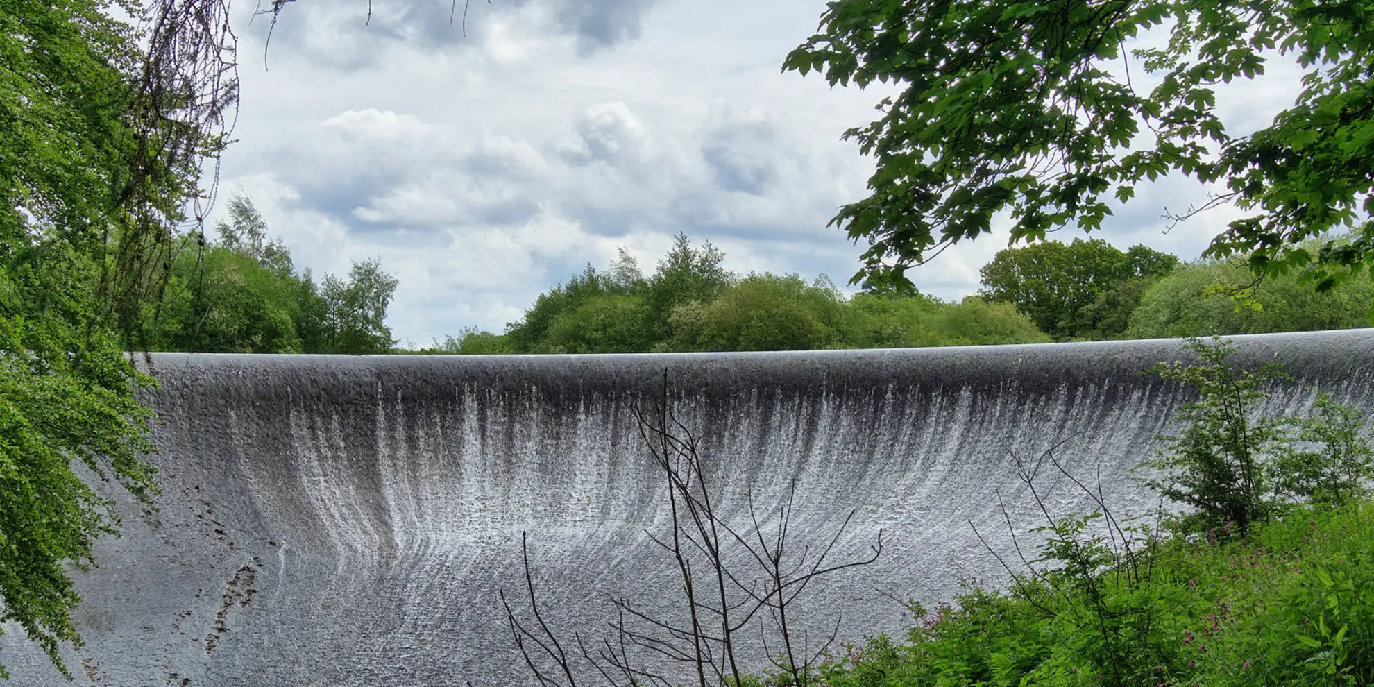 An image depicting the trail Abbeystead Reservoir from Stoops Bridge and its surrounding area.