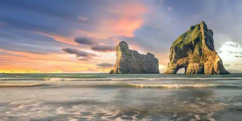 An image depicting the trail Wharariki Beach via Wharariki Road and its surrounding area.
