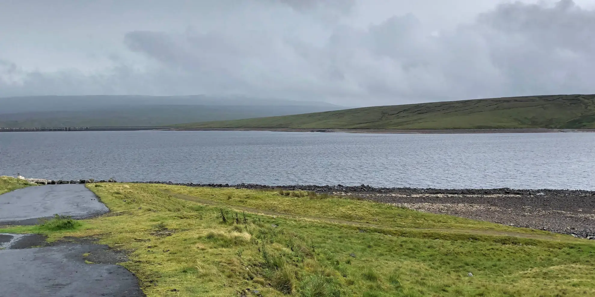 An image depicting the trail High Cup Nick from Cow Green Reservoir and its surrounding area.