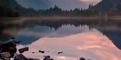 An image depicting the trail Glendalough Upper and Lower Lakes Loop and its surrounding area.